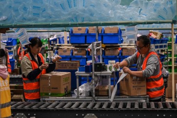 In this picture taken on November 6, 2020, employees work in the warehouse of Cainiao Smart Logistics Network, the logistics affiliate of e-commerce giant Alibaba, in Wuxi, China's eastern Jiangsu province, ahead of Singles' Day, also known as the Double 11 shopping festival - the world's biggest shopping event - which falls on November 11. (Photo by Hector RETAMAL / AFP)