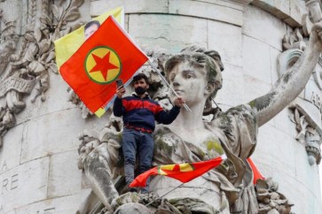 رجل يحمل علم حزب العمال الكردستاني خلال احتجاجات في ساحة الجمهورية في باريس احتجاجا على مقتل 3 أشخاص من الأكراد أمس في العاصمة الفرنسية (رويترز)