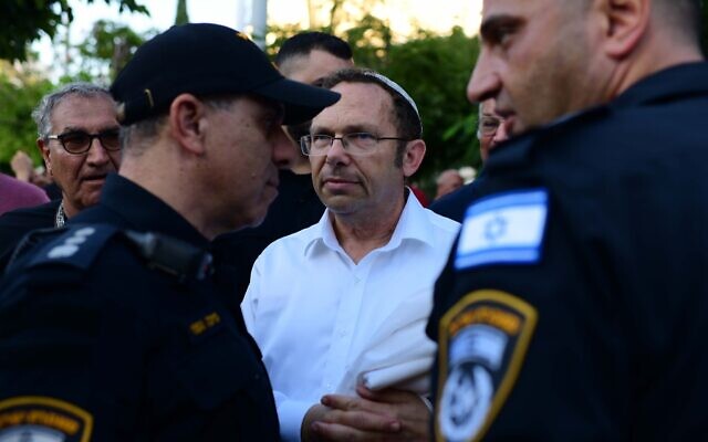 يسرائيل زعيرا، رئيس منظمة “روش يهودي” الأرثوذكسية، يتحدث مع أفراد الشرطة بينما تقيم المجموعة حاجزا يفصل بين الجنسين