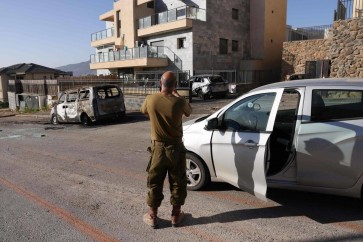 An Israeli soldier takes a picture of damaged vehicles and a building after a rocket attack from southern Lebanon on the Israeli city of Kiryat Shmona in northern Israel on November 6, 2023, amid the ongoing battles between Israel and the Palestinian group Hamas. Lebanon's Hezbollah movement said it fired Katyusha rockets at the northern Israeli town of Kiryat Shmona in response to the killing of four people, a woman and her three grandchildren aged 10, 12 and 14, and the injuring of their relative a radio correspondent, in an Israeli strike on southern Lebanon, the official Lebanese news agency said. (Photo by Jalaa MAREY / AFP)