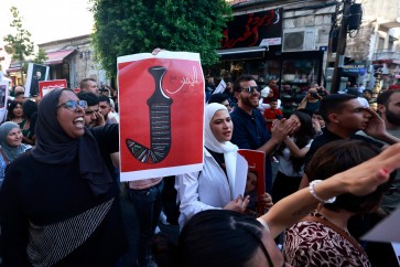 متظاهرة في رام الله تحمل لافتة مؤيدة للضربة اليمنية على تل أبيب