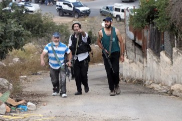 مستوطنون مسلحون يتجولون في الضفة الغربية المحتلة (الفرنسية)